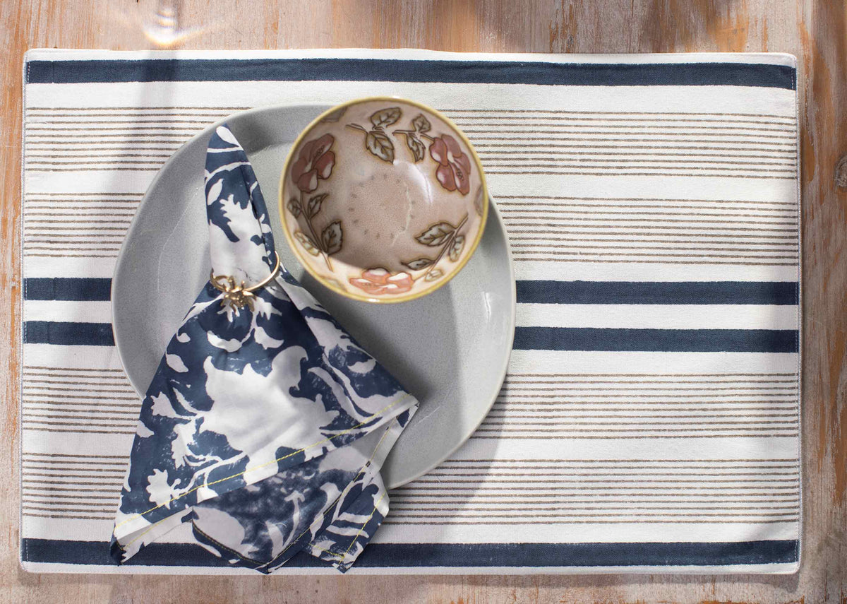 Cardinal Dinner Napkins in navy floral print folded through a napkin ring.