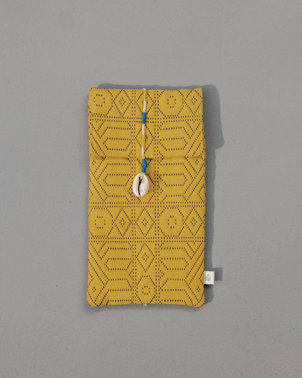 Yellow Jacquard Spectacle Case with a cowrie shell tie, closed.