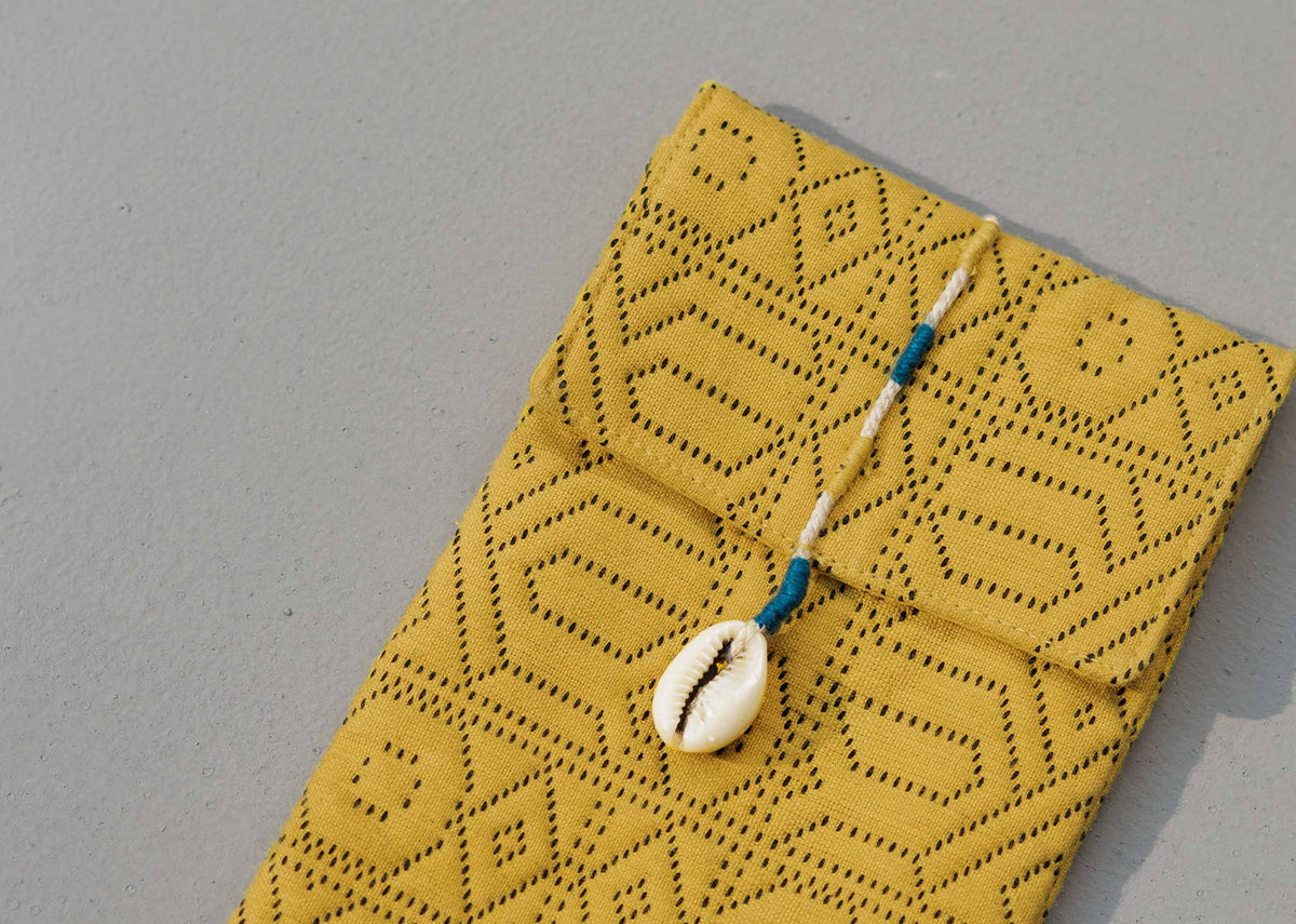 Close-up of Jacquard Spectacle Case showing its geometric pattern and cowrie tie.
