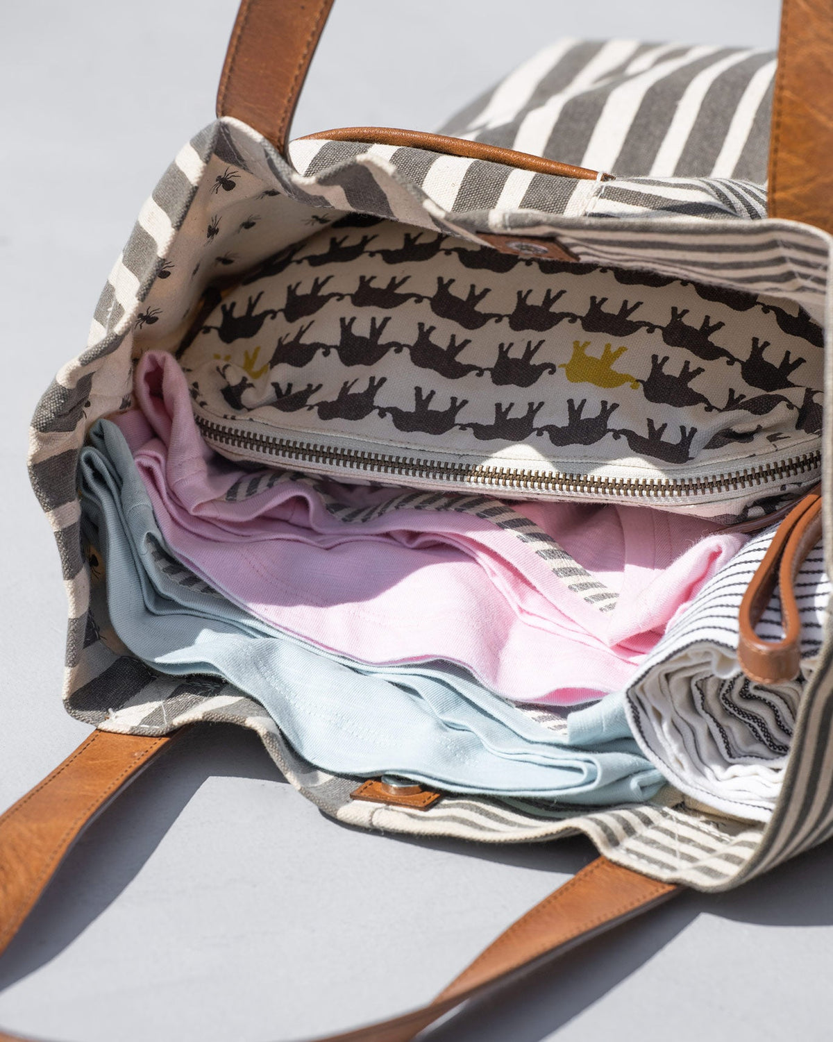 Inside of a Berber stripe tote with a printed lining and a zip pocket.