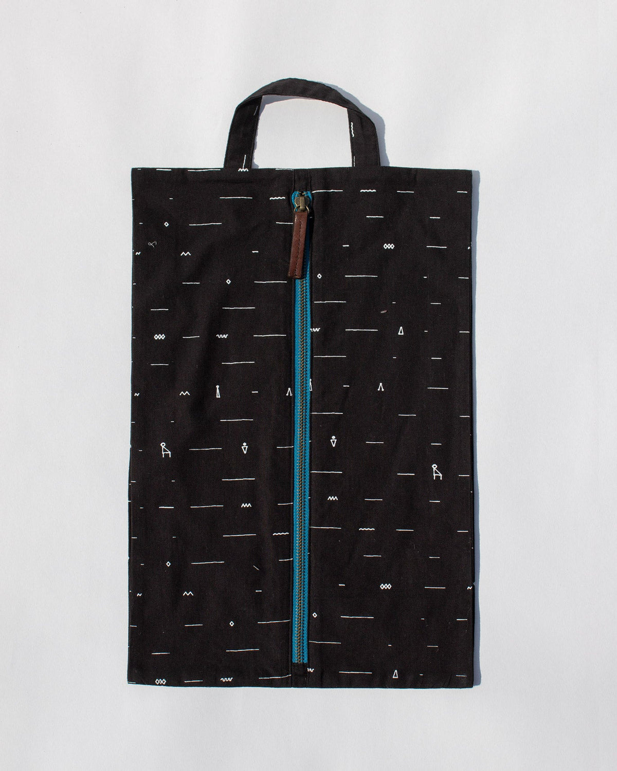 Black Musafir shoe sack with a top handle and teal zip.