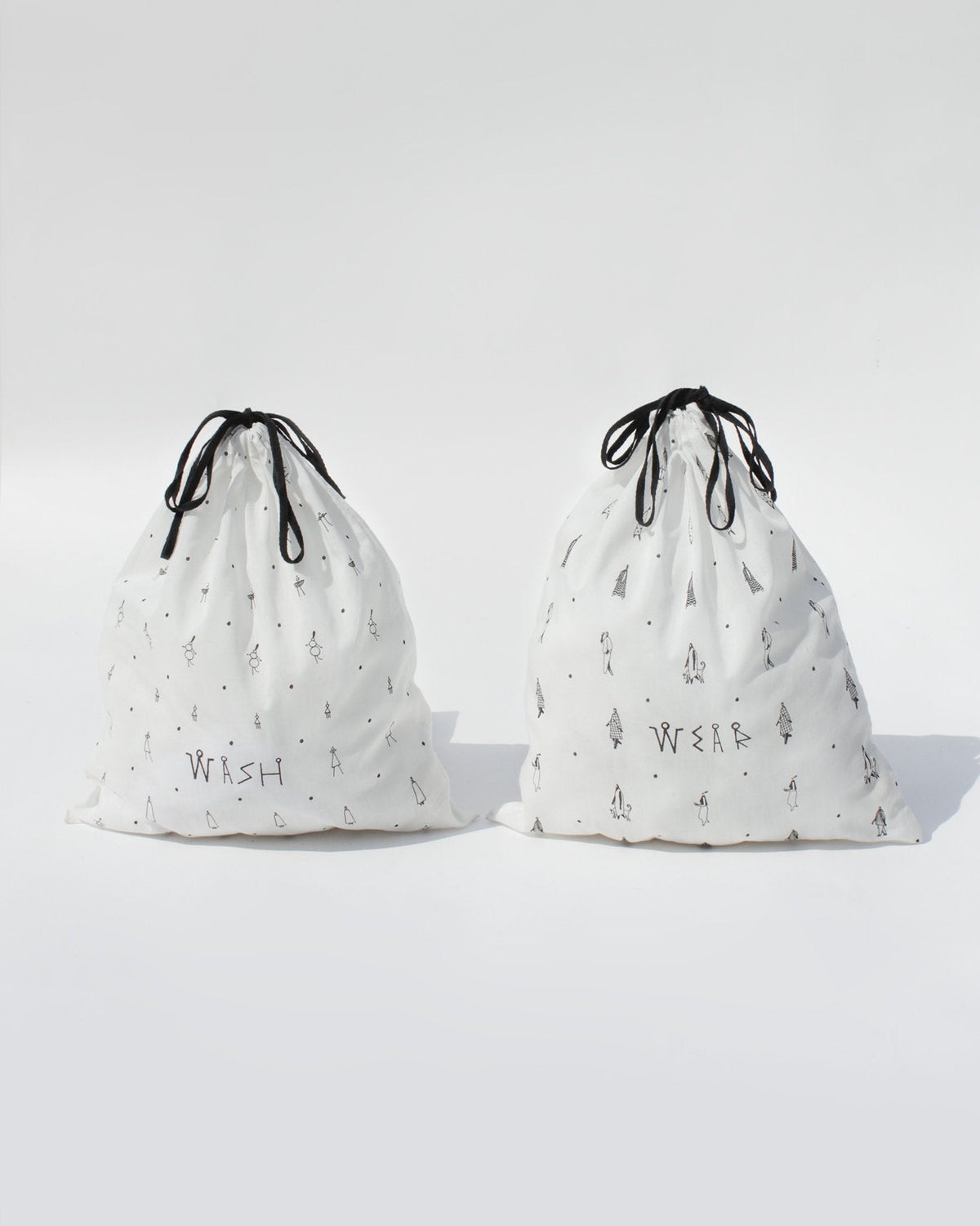 Musafir wash and wear bags standing upright with black drawstrings tied.