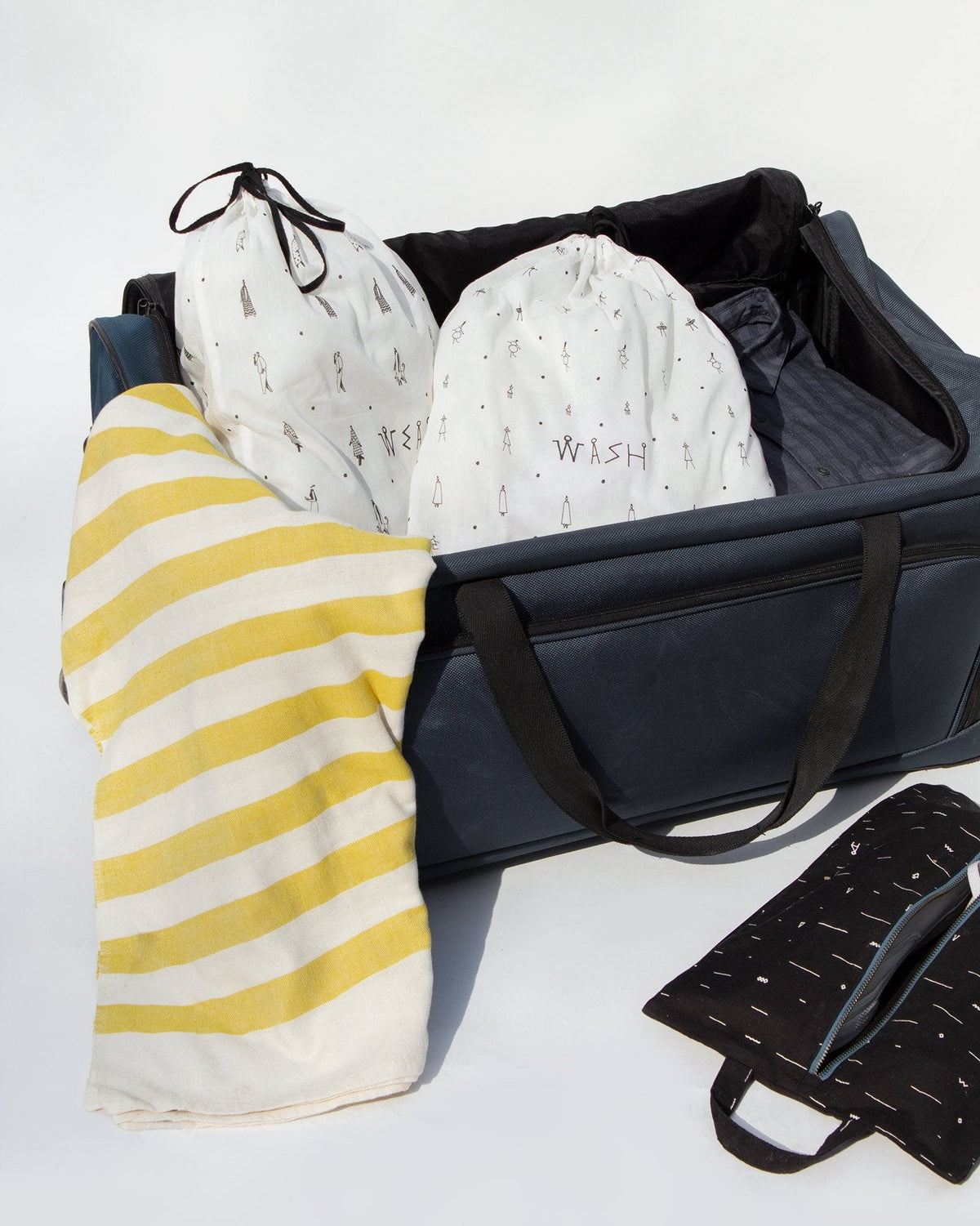 Musafir wash and wear bags tucked into an open suitcase.