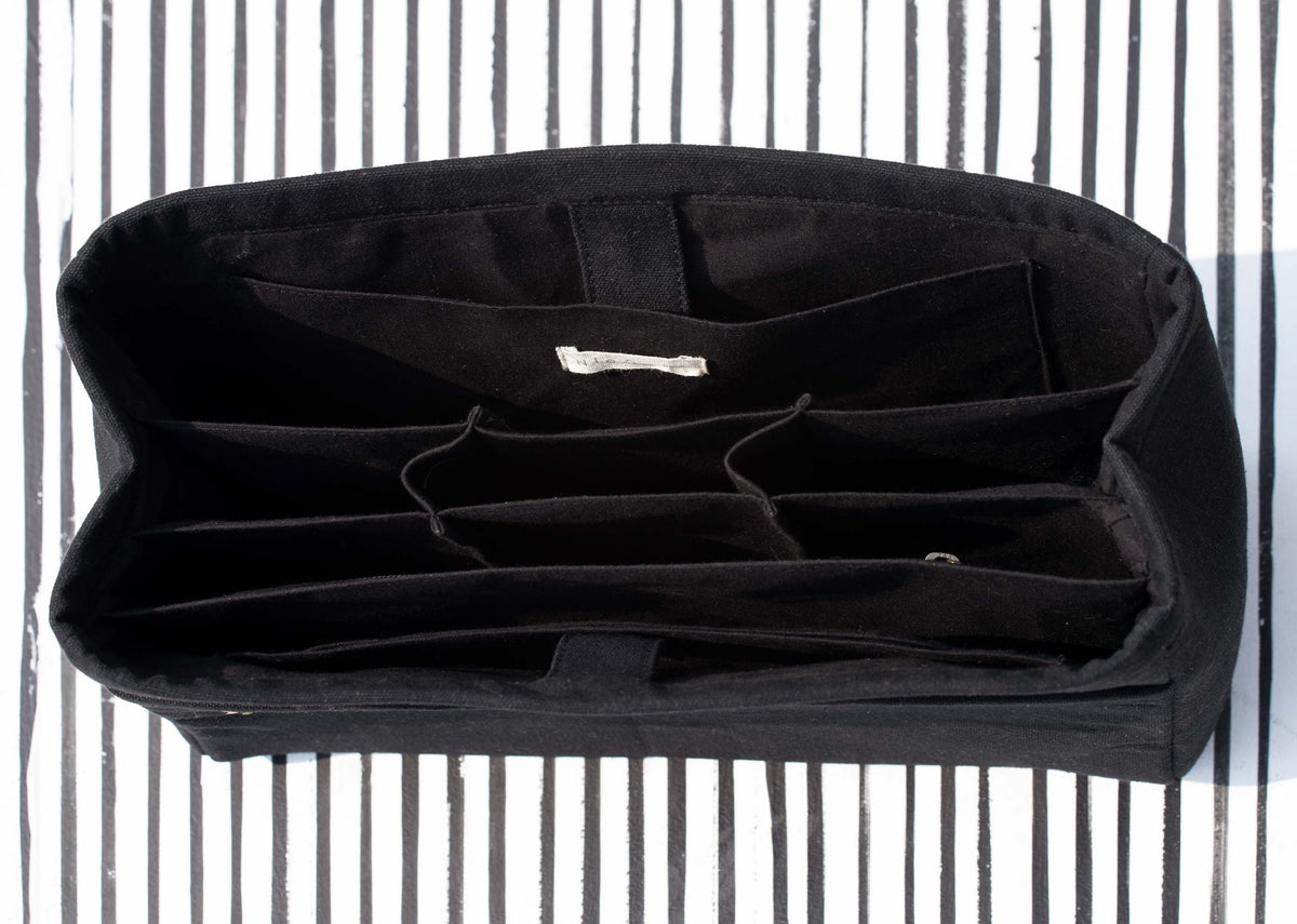 Open Musafir Zenbu organiser showing its black interior compartments.