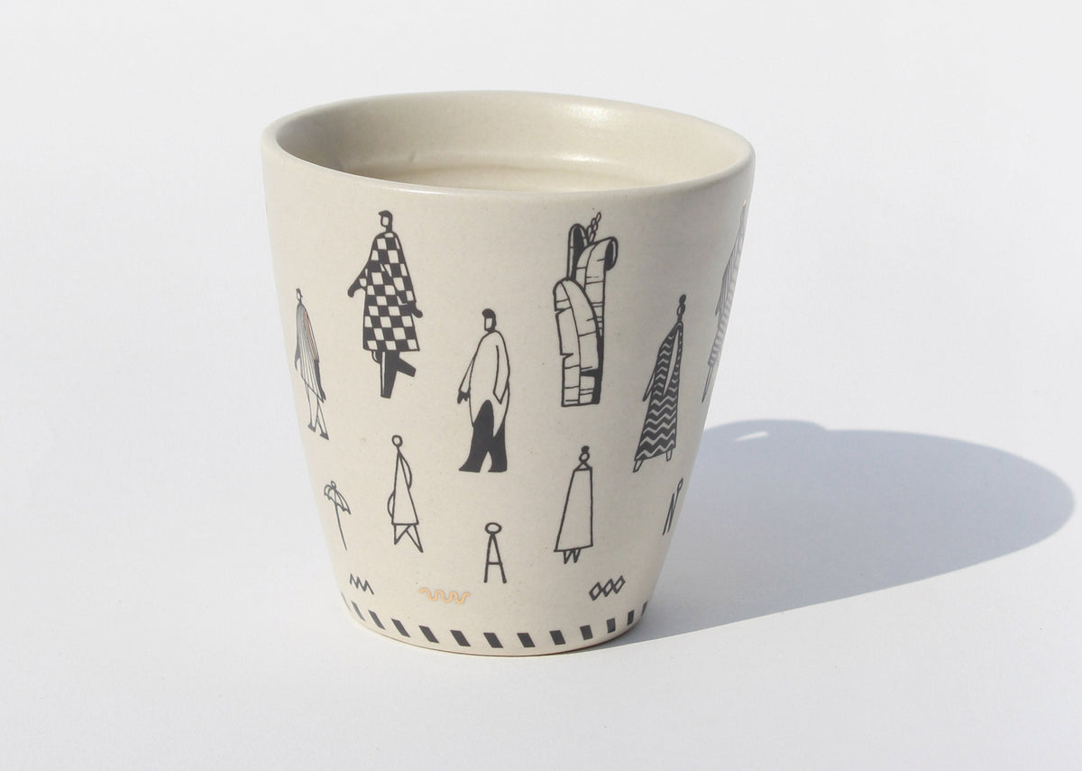 Handleless Musafir cup with black figure drawings around its side.