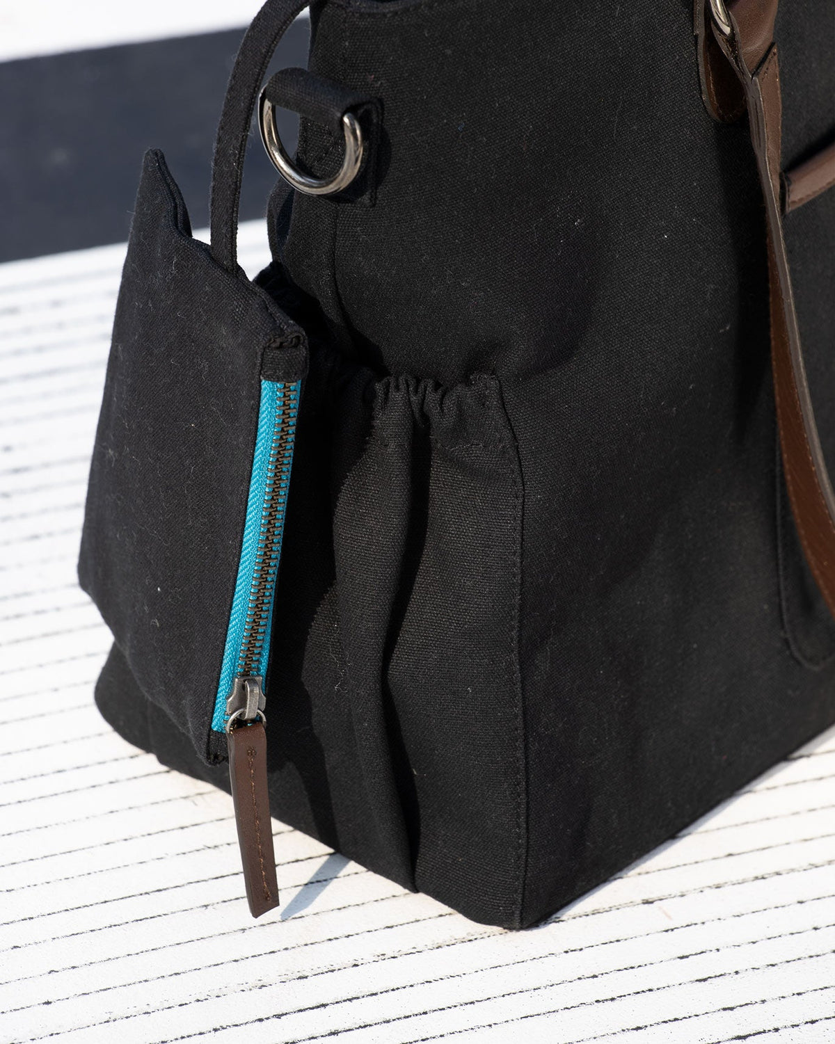Close-up of the Perfect Work Bag's side zip pocket with a blue zip.