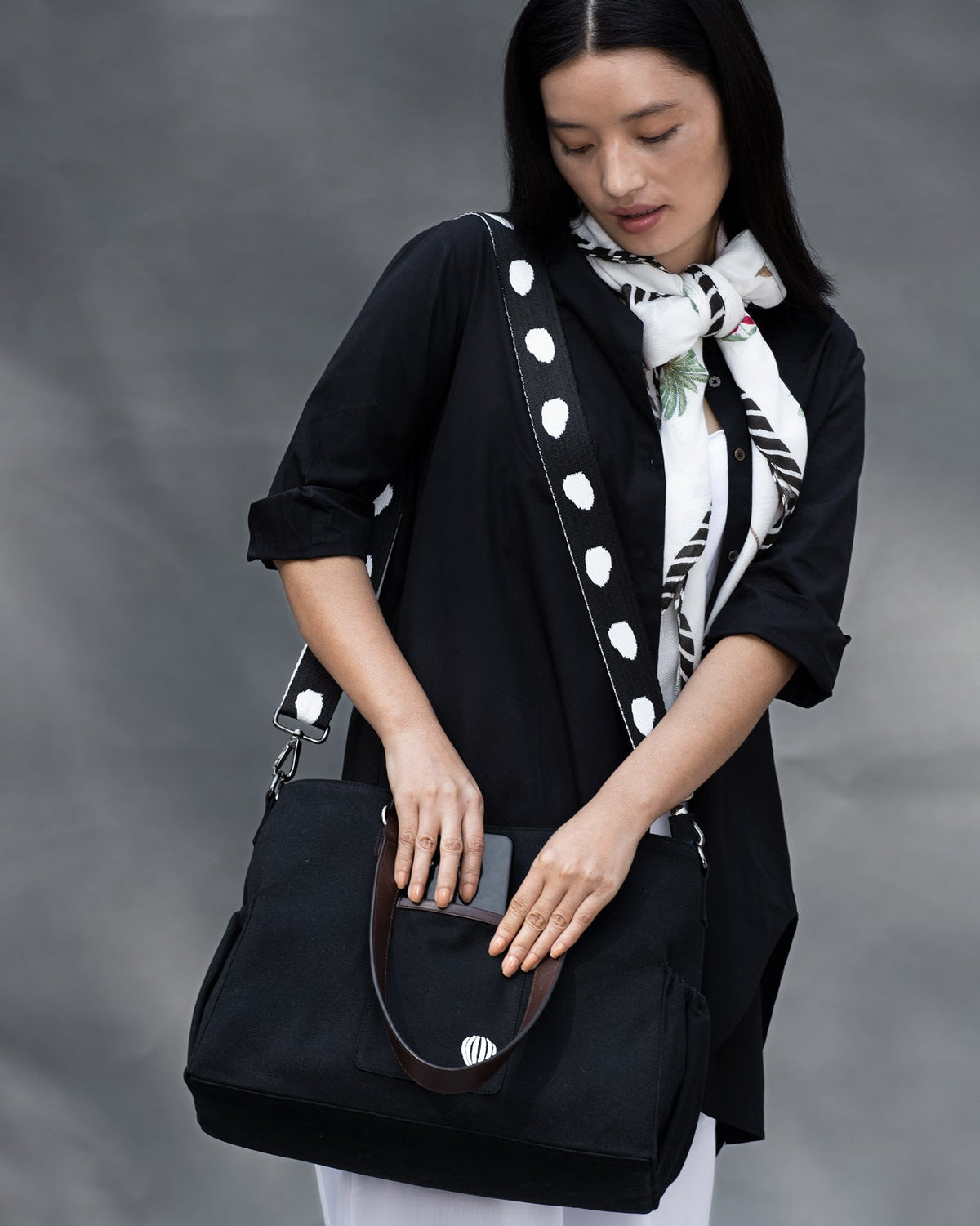 Person carrying the Perfect Work Bag over one shoulder by its polka-dot strap.