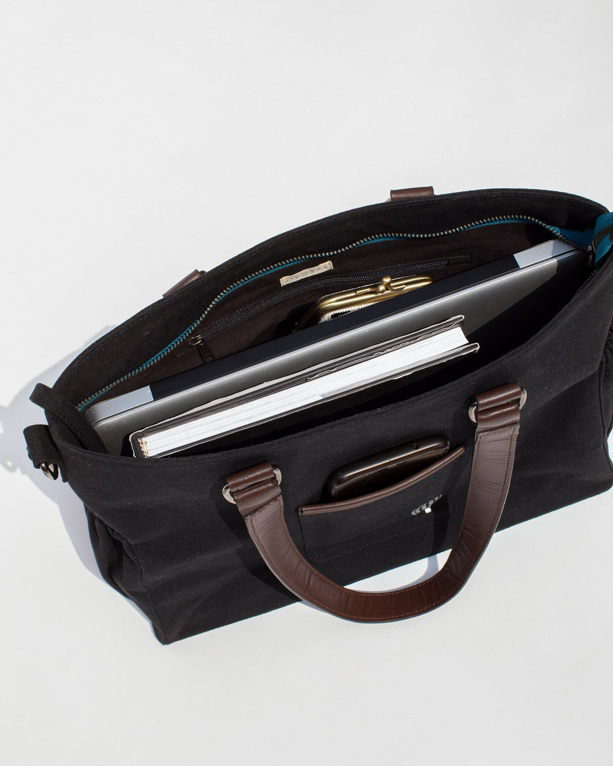 Perfect Work Bag open on a white surface, showing its black interior.