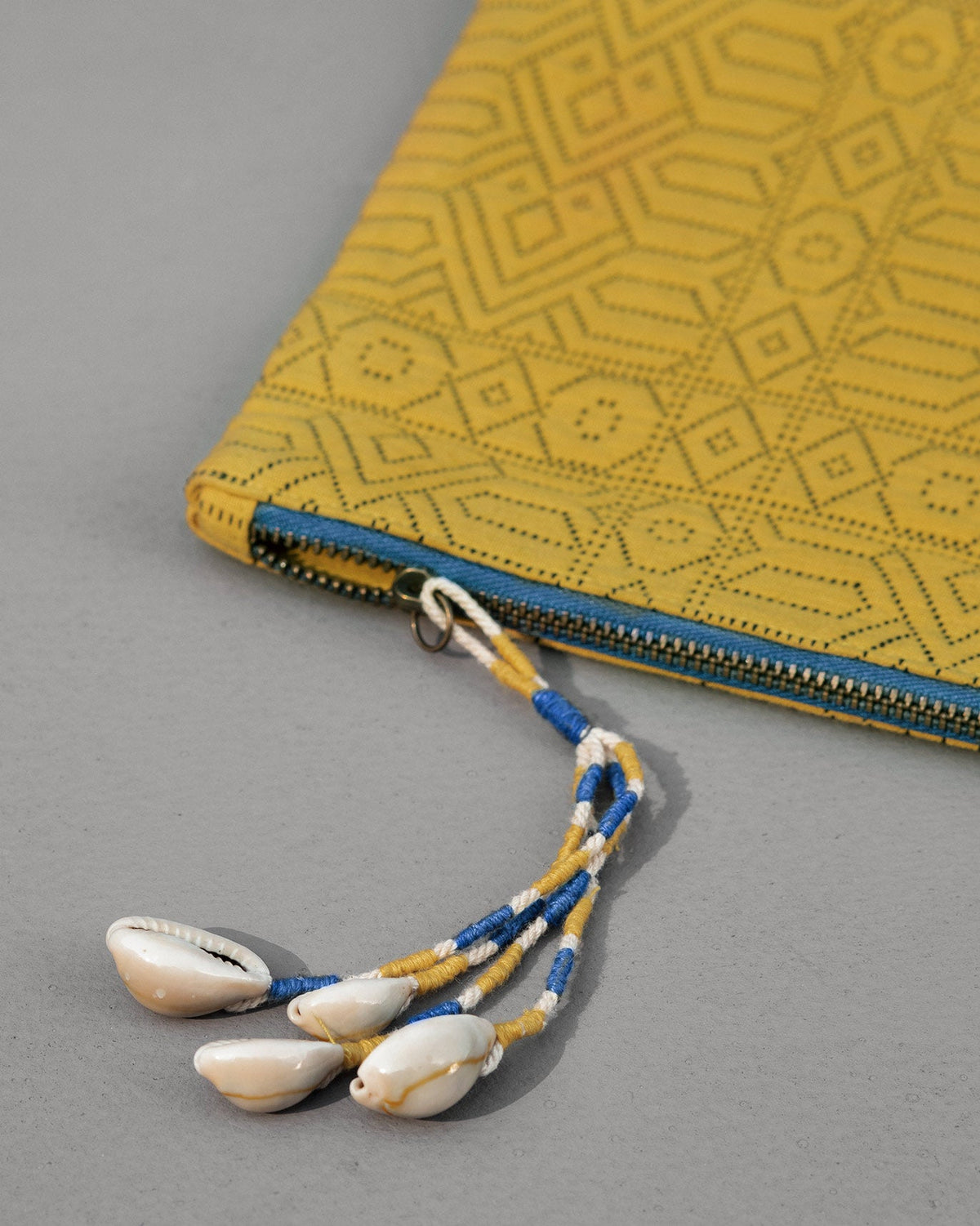 Close-up of Jumbo Jacquard Pouch showing its cowrie shell tassel.