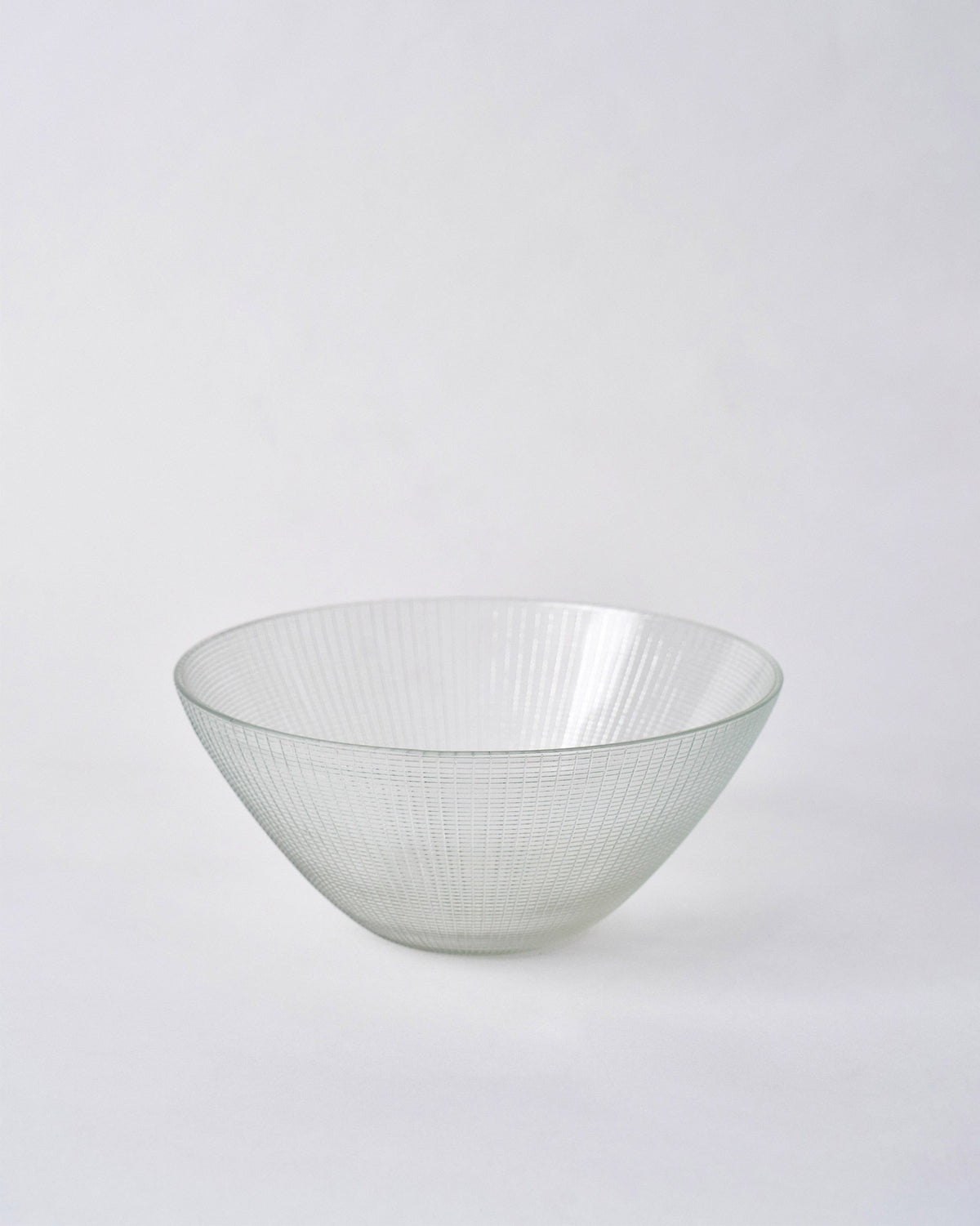 Aire Serving Bowl in clear glass with fine vertical ridges.