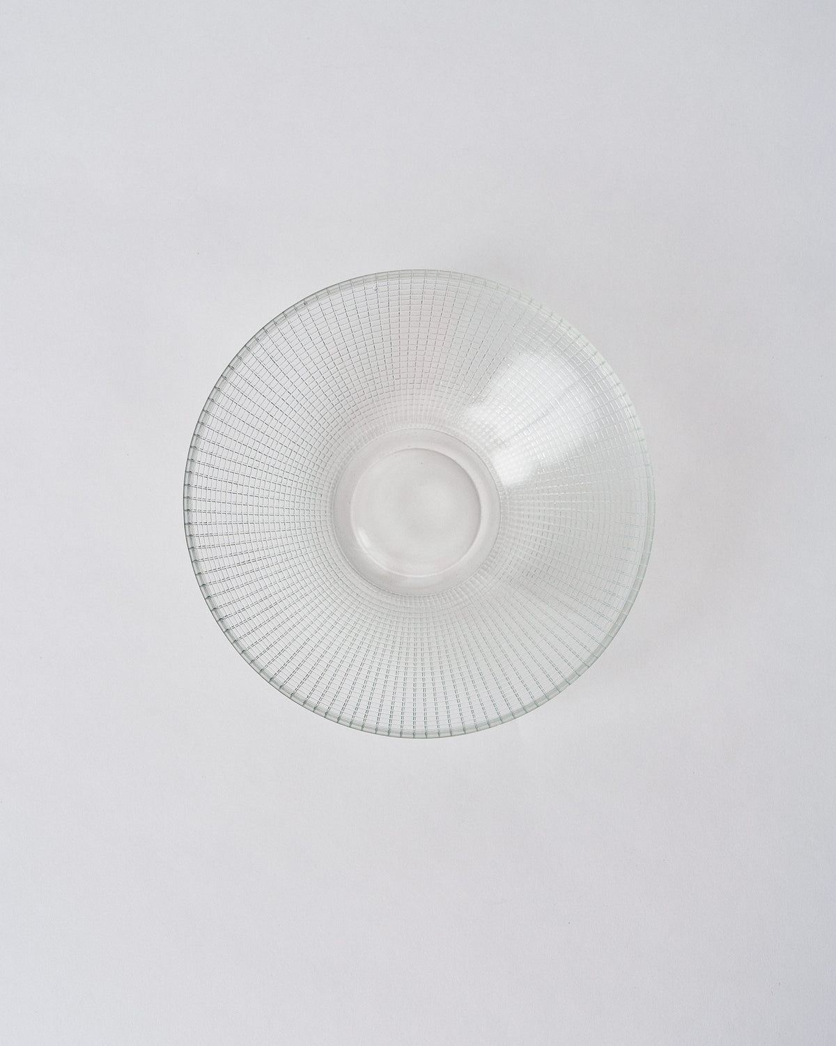 Looking down into a clear Aire bowl with a geometric grid etch and smooth base.