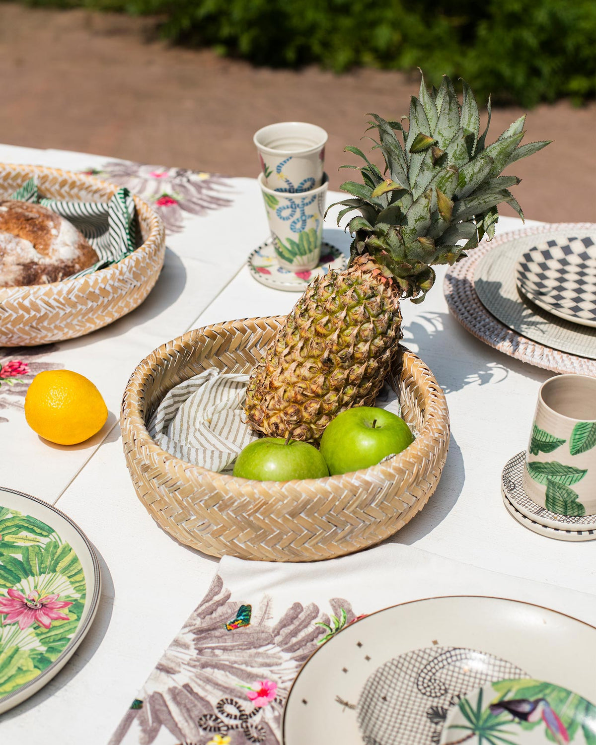Double Walled Bamboo Fruit Basket holding a pineapple and green apples.