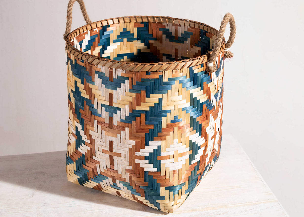 Bolga Bamboo Basket standing on a woven floor mat.