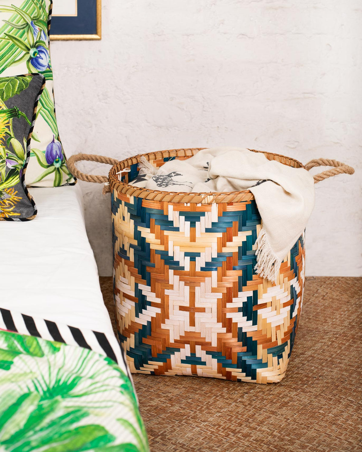 Three-quarter view of a Bolga Bamboo Basket with a teal, orange and cream geometric weave.