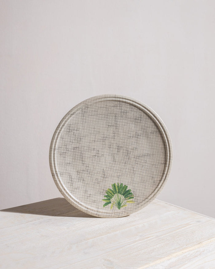 Madagascar dinner plate with crosshatch texture and a small palm motif.