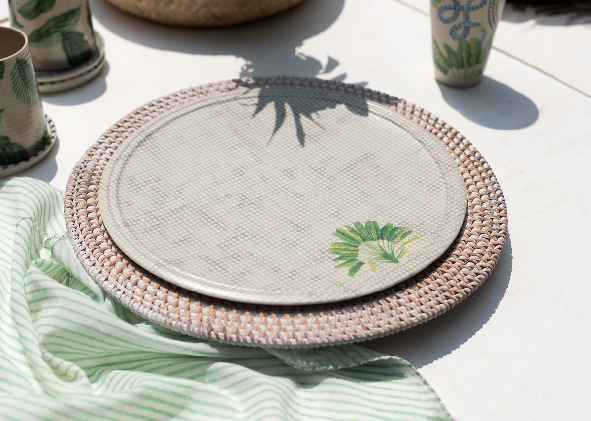 Madagascar dinner plate on a rattan charger in an outdoor table setting.