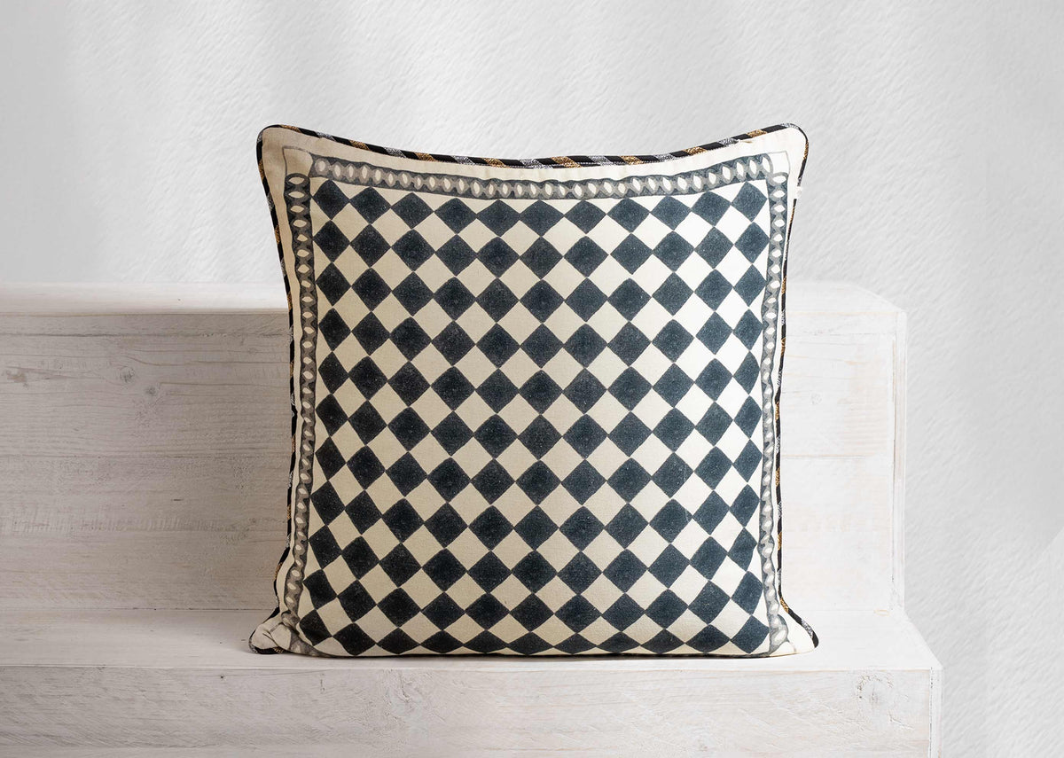 Arabesko cushion cover in charcoal and cream diamond checker print with a dotted border.