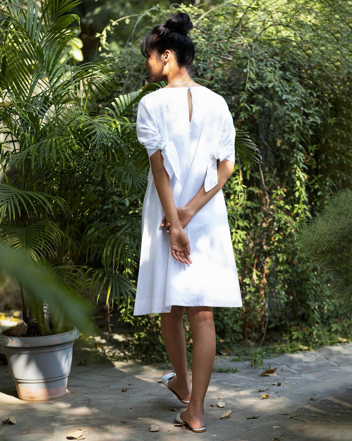 Back of a white A-line Dress with a keyhole neckline, worn by a person.