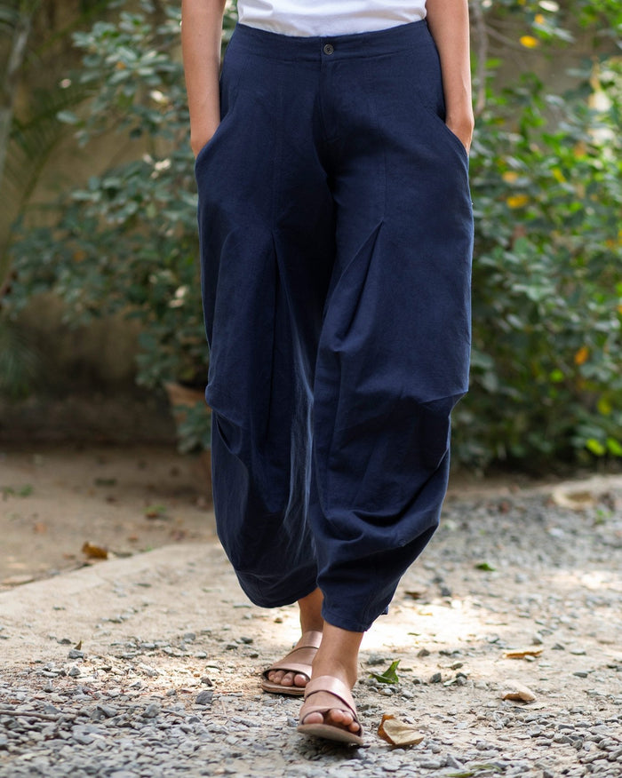 Person wearing blue Weekend Trousers with draped, pleated legs.