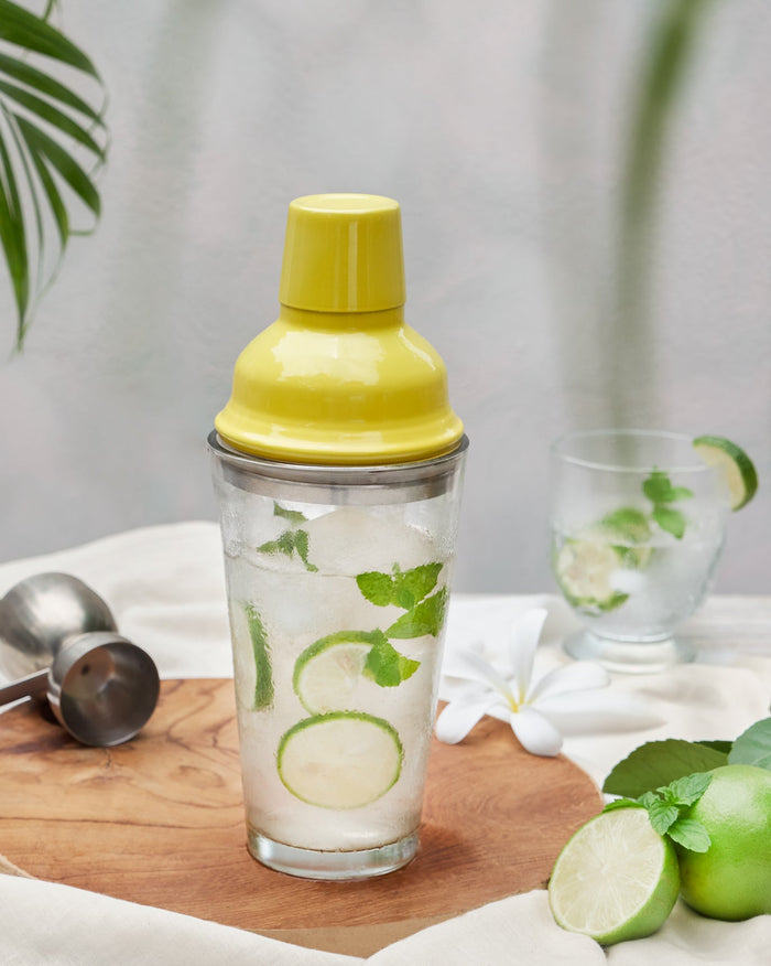 Riverside Cocktail Shaker - Yellow with a yellow lid, filled with ice and lime.