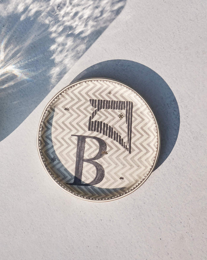 Akshar Coaster with a large letter B on a grey chevron pattern.