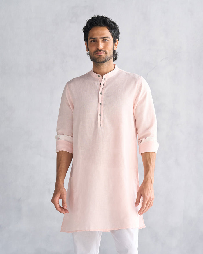Person wearing a pink Chandni Chowk kurta with a Nehru collar.