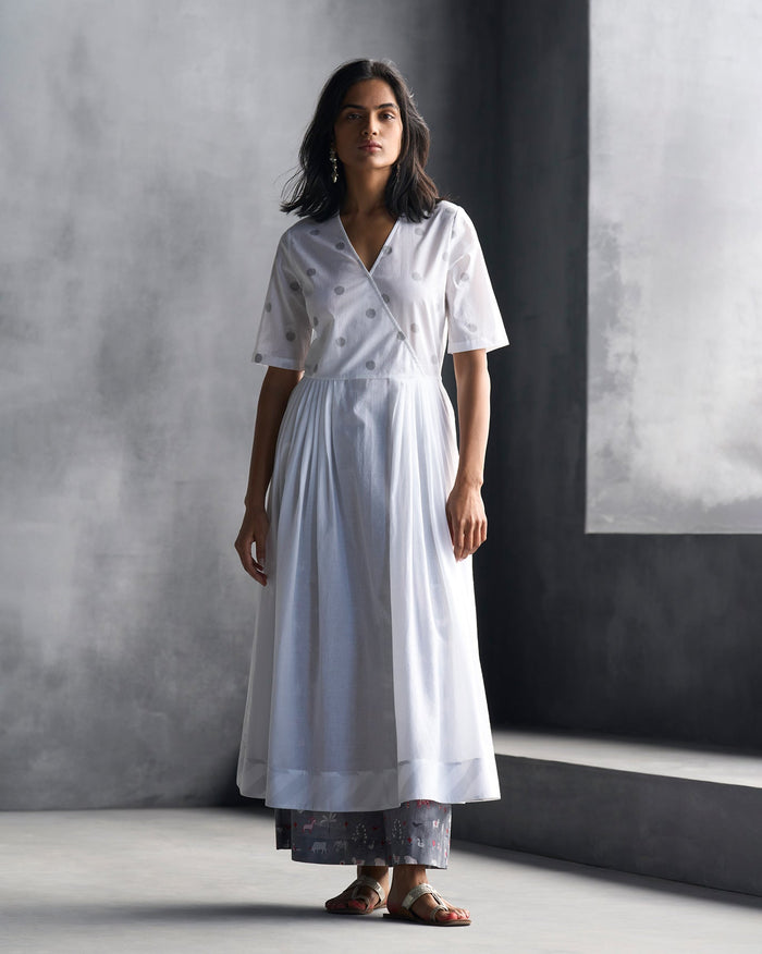 Person wearing a white front-overlap yoke kurta with grey ikat dots.