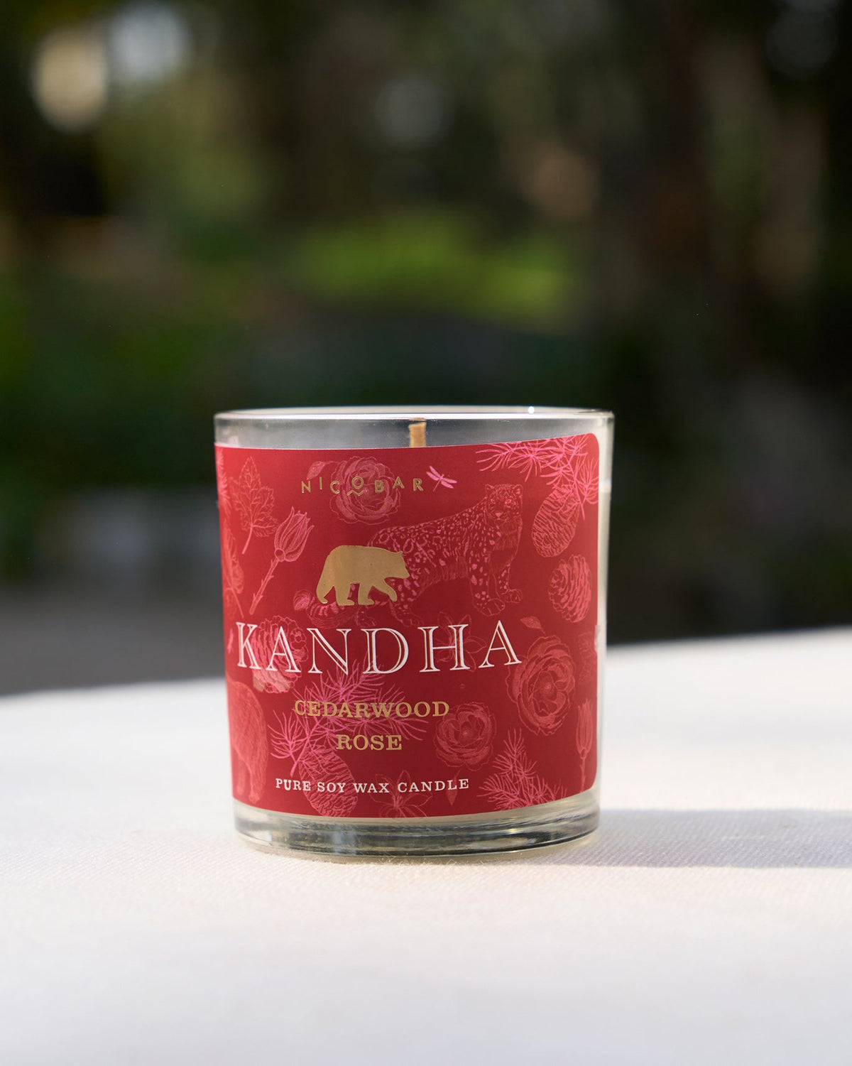 Kandha Candle Cedarwood - Rose in a glass jar with a bear motif.