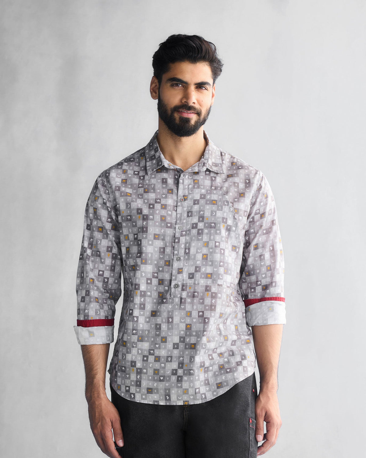 Person wearing a grey Pocket Shirt with a small tile print and red cuff trim.