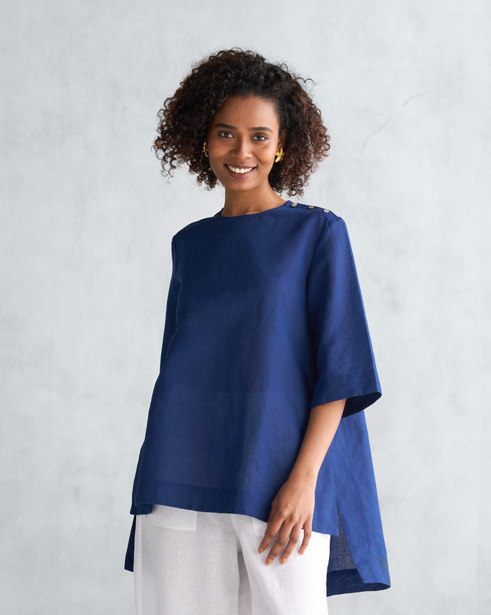 Person wearing a navy High slit top with three-quarter sleeves.