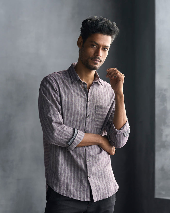Person wearing a grey Zulu Shirt with vertical stripes and a chest pocket.