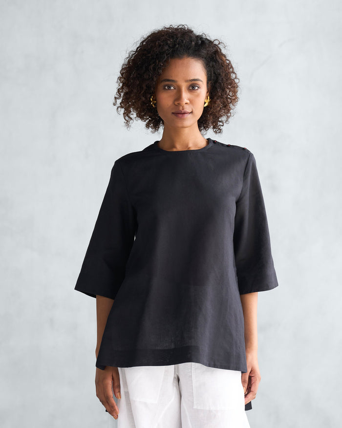 Person wearing a black High Slit Top with shoulder buttons.