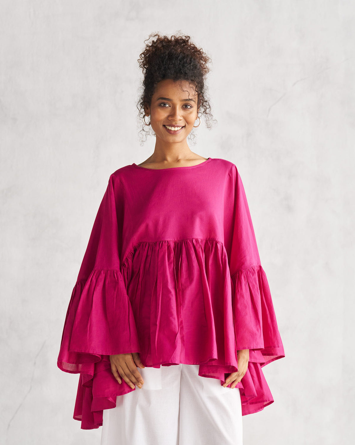Person wearing a berry Frill Top with tiered flared sleeves.