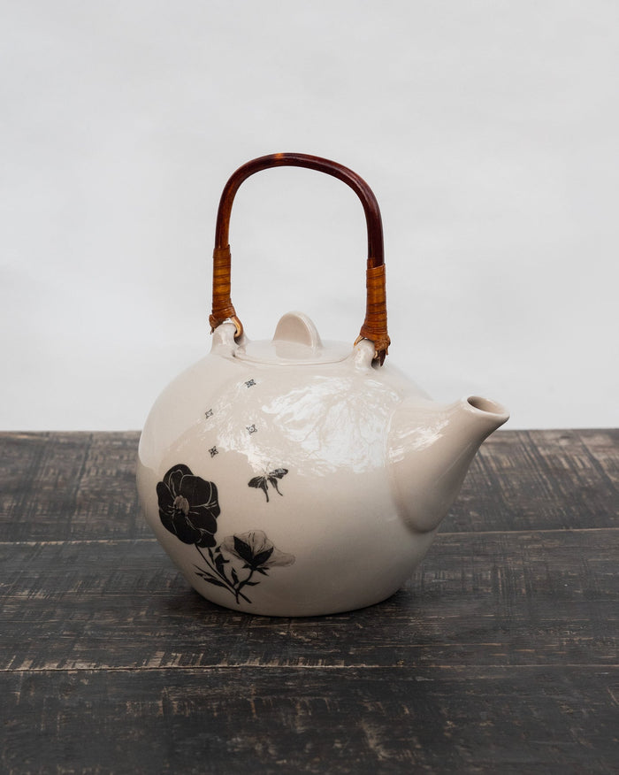 Ivory Poppy teapot with dark wooden handle and black poppy motif.
