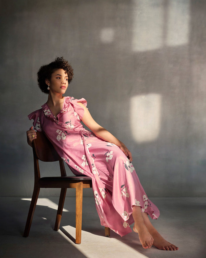 Person seated in pink Floral Maxi Dress with Slip and a wrap front.