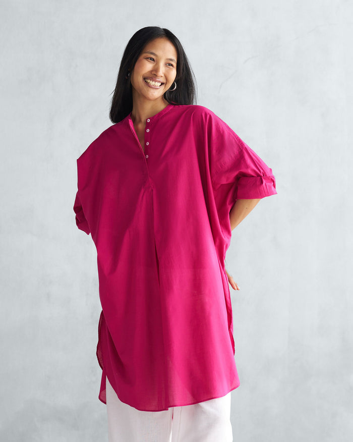 Person wearing a berry Lazy Sunday tunic with a band collar and buttoned placket.