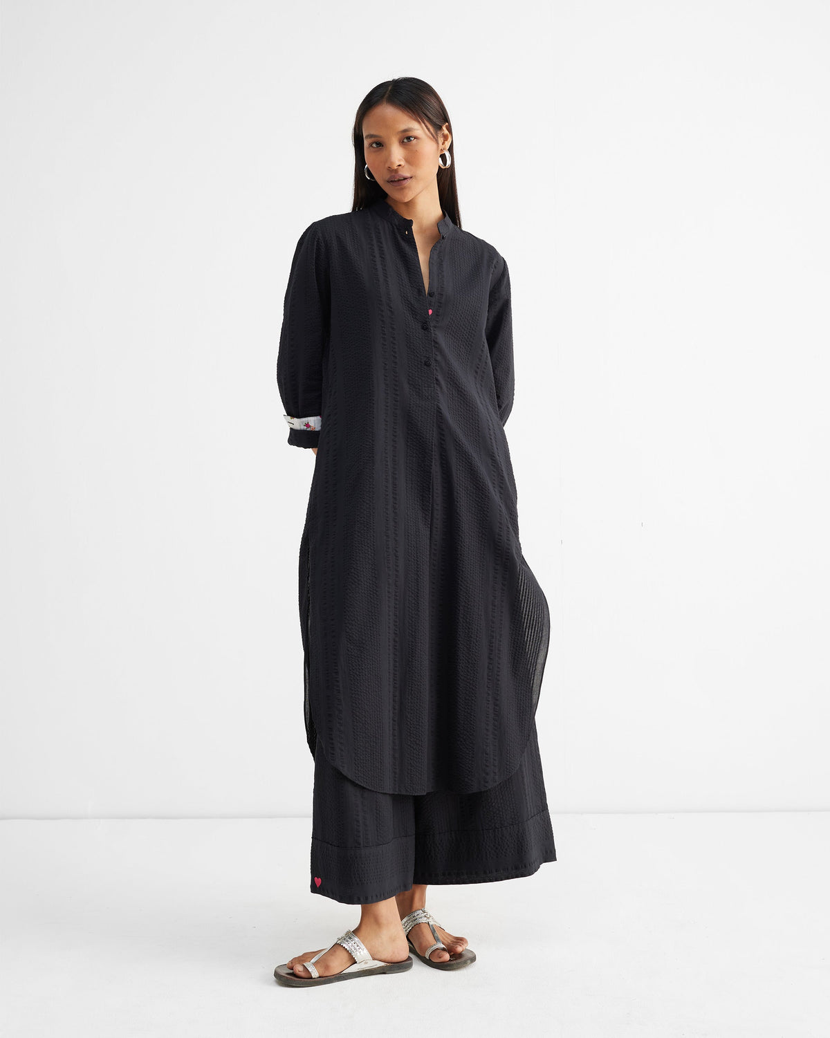Person wearing the Basic Long Length in black seersucker with a button placket.
