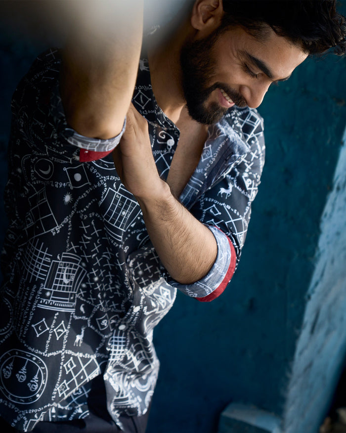 Person wearing a Kochi Shirt in black and white print with red cuff lining.