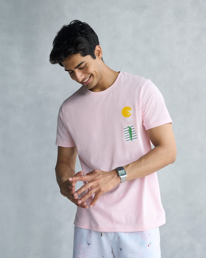 Person wearing a soft pink See Ya Later Alligator t-shirt with a sun and alligator print.