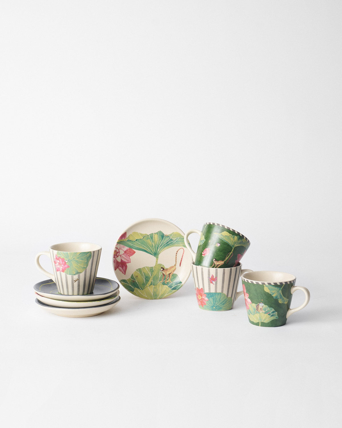Float tea plates with monkey and lotus motifs beside matching mugs.