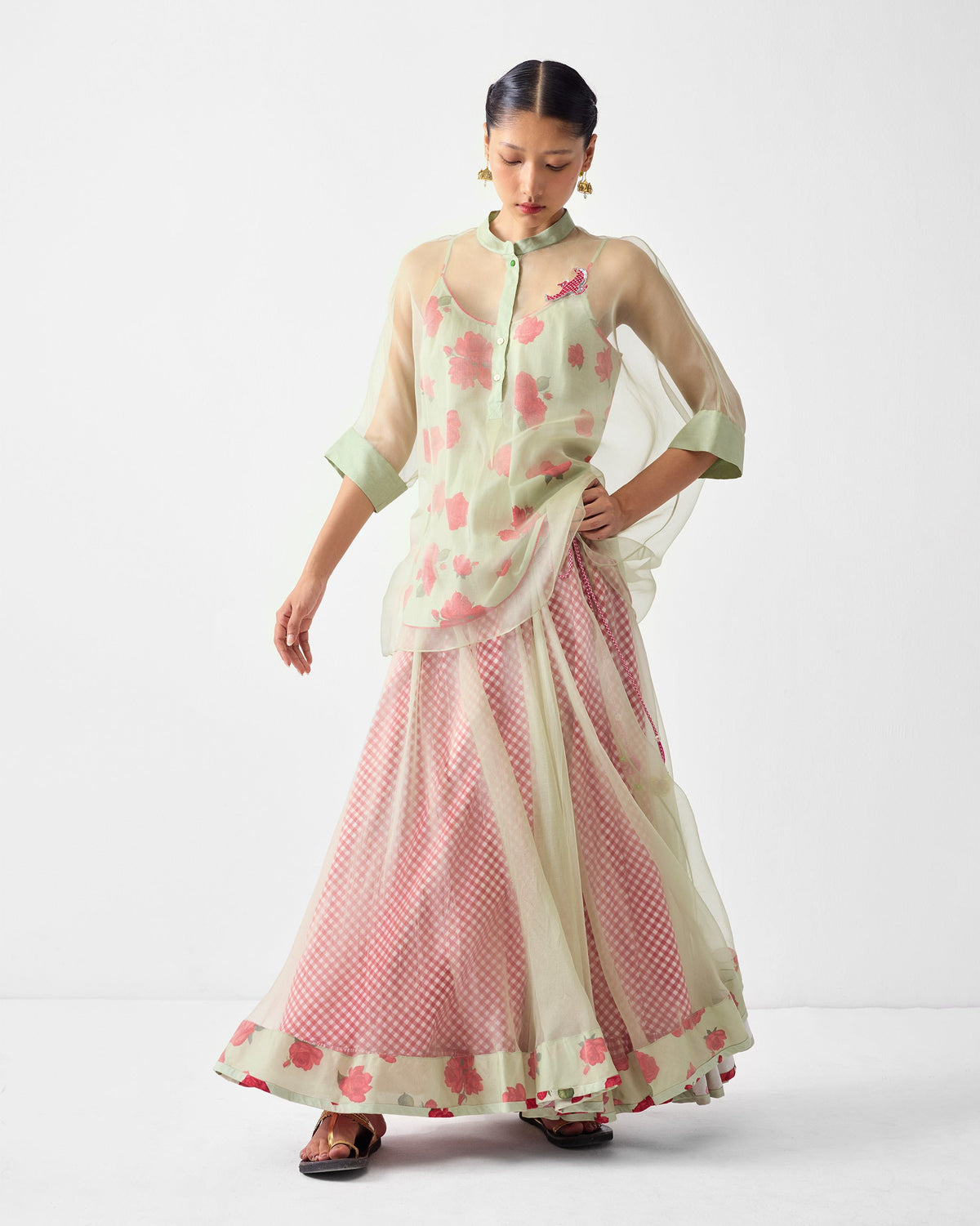 Person wearing a Pushkar Skirt under a mint sheer top with pink florals.