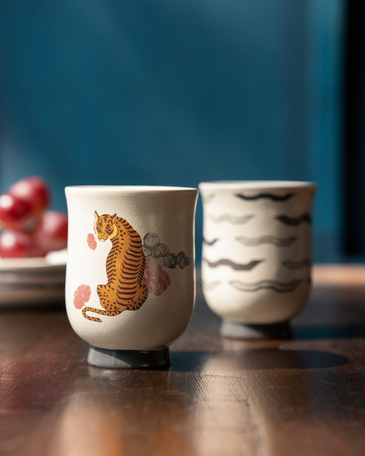 Sitara tea cup with an orange tiger and pink clouds on a black base.