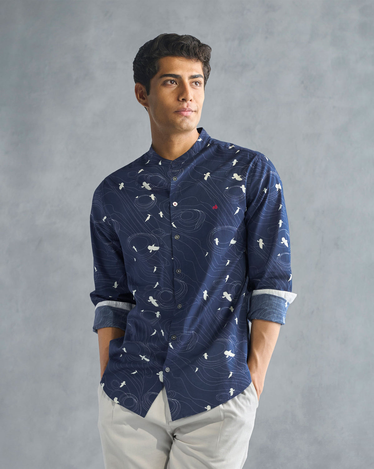 Person wearing a deep navy Nawab shirt with a white bird print.
