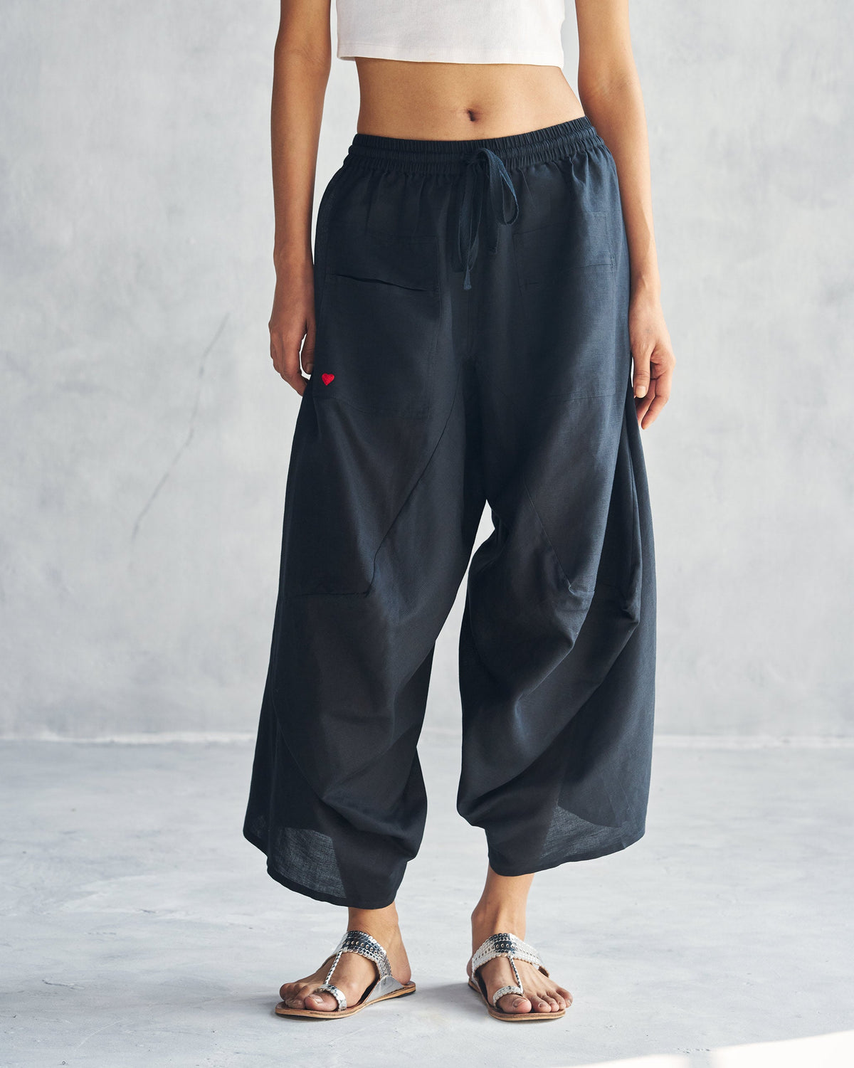 Person wearing black Yoka trousers with a drawstring waist.