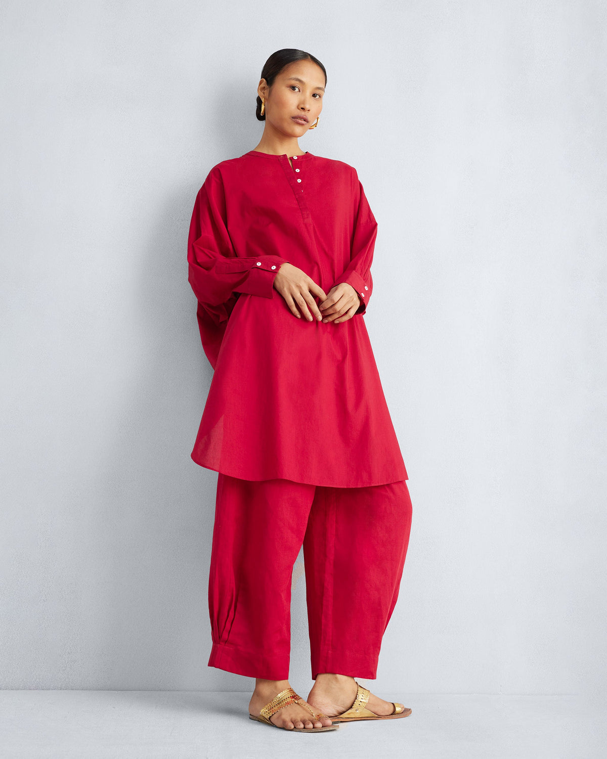 Person wearing red wide-leg cropped pants with a gathered hem.