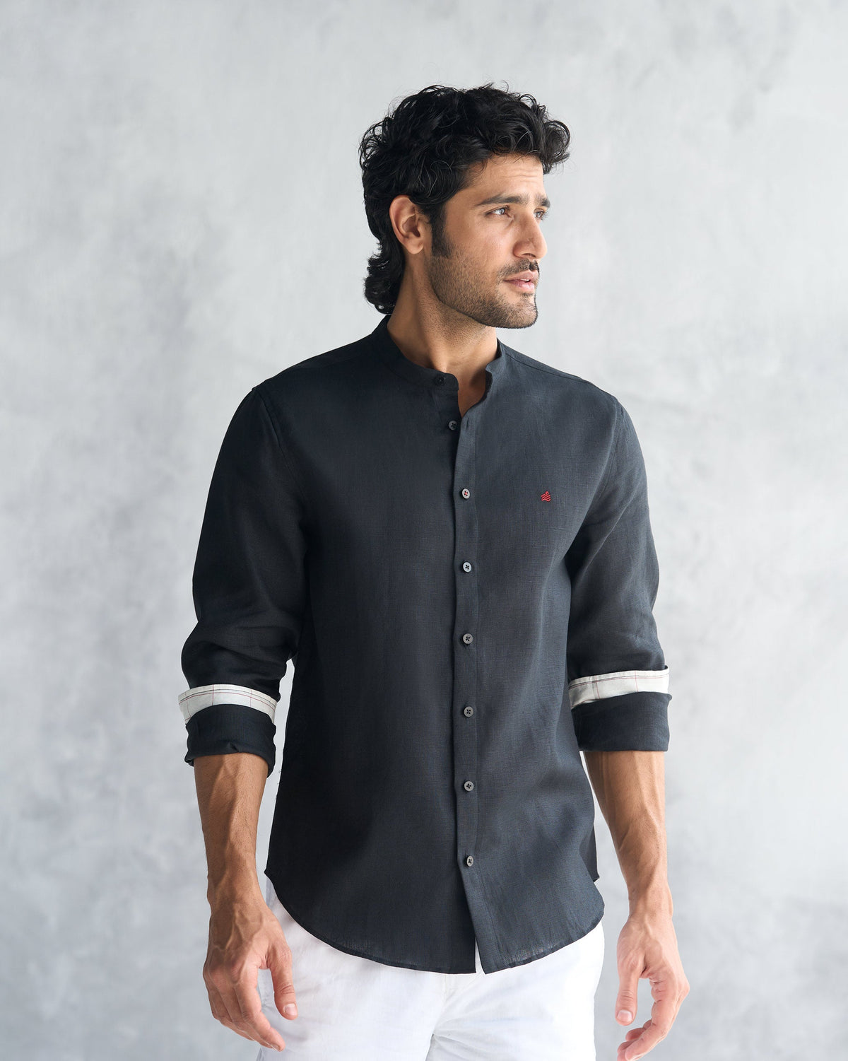Person wearing a black Nawab Shirt with a band collar and red chest mark.