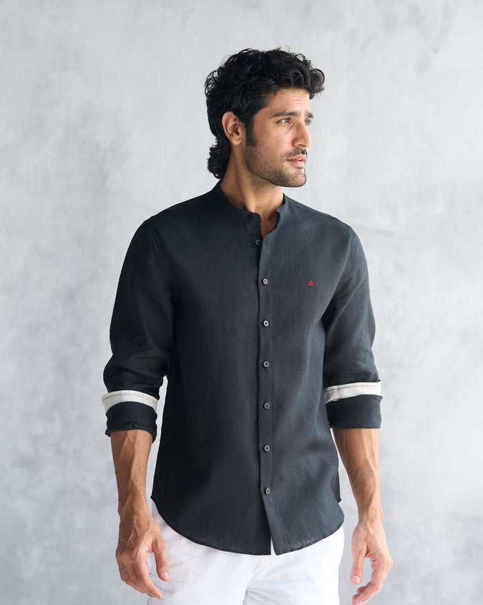 Person wearing a black Nawab Shirt with a band collar and red chest mark.