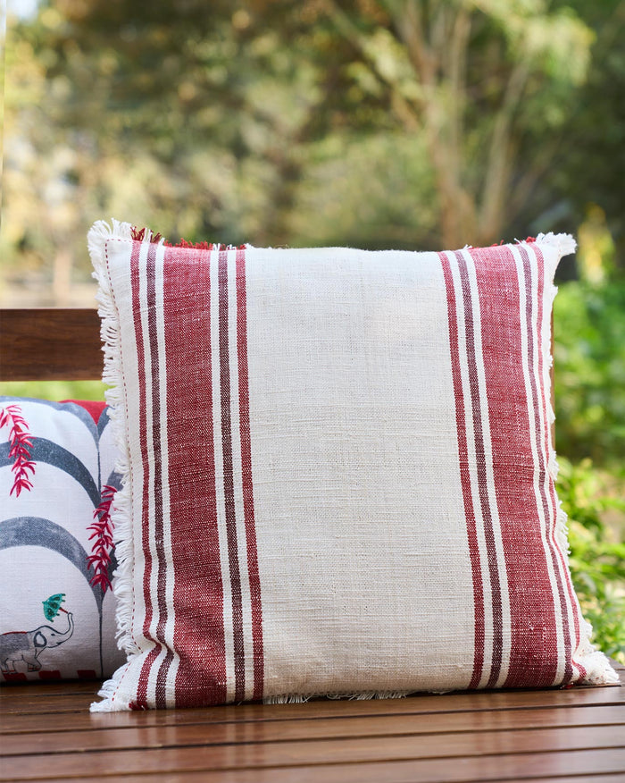 Cara Cushion Cover in cream with red stripes and fringed edges.
