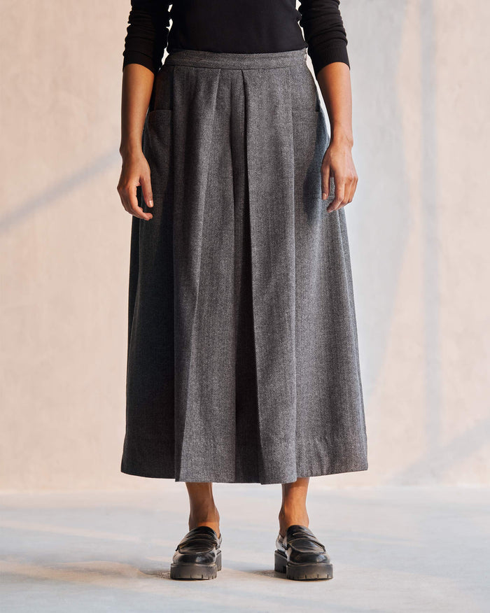 Person wearing a grey Pocket Skirt with front pleats.