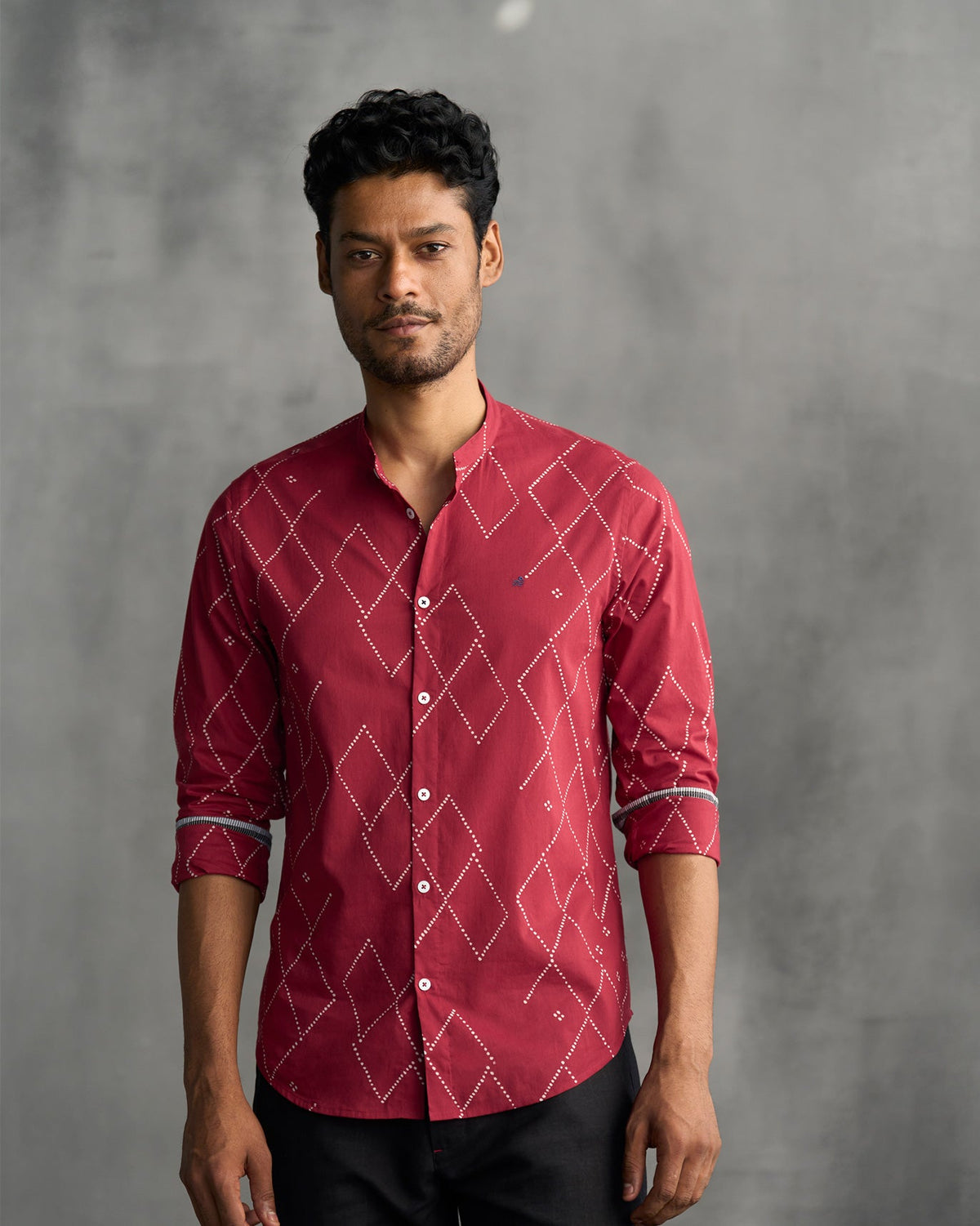 Person wearing a red Nawab shirt with white dotted diamond lines.